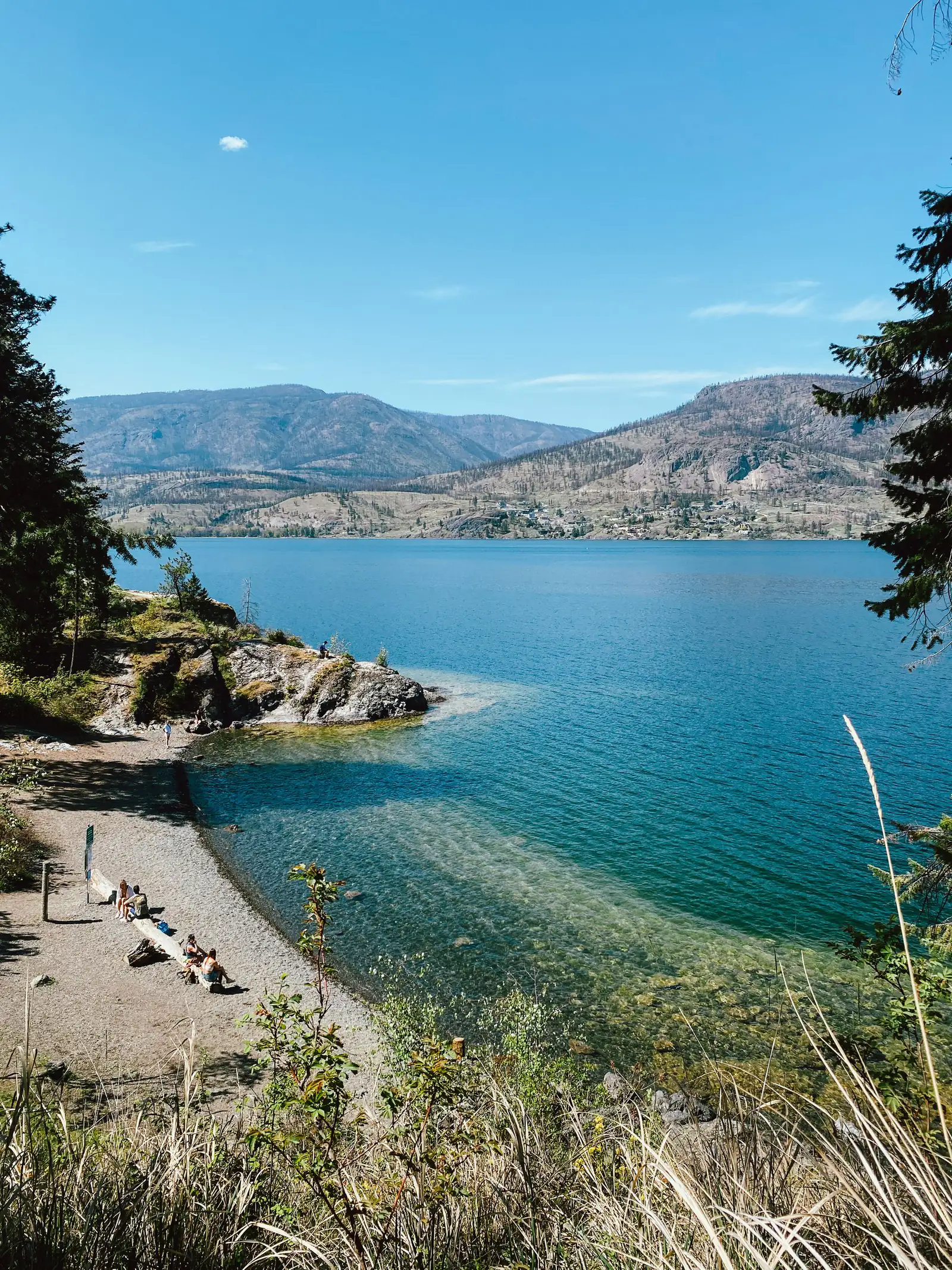 Clear turquoise water and a rocky point on Okanagan Lake
